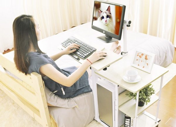 a bedside table in the bedroom with a computer