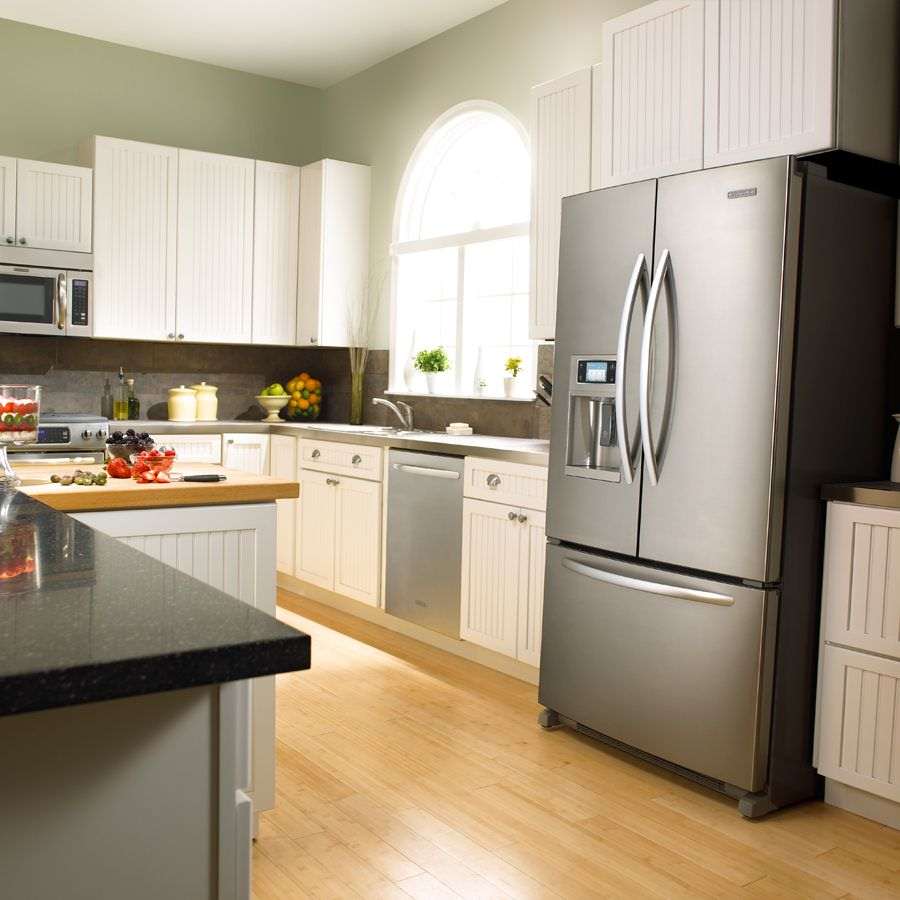 a small refrigerator in the design of the kitchen in beige color