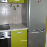 small refrigerator in the interior of the kitchen in dark color photo