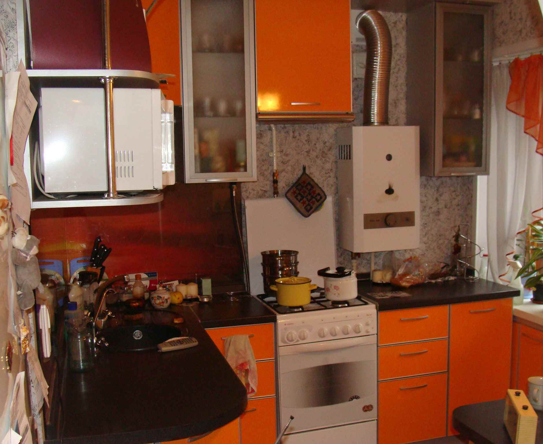 An example of a light kitchen decor with a gas water heater