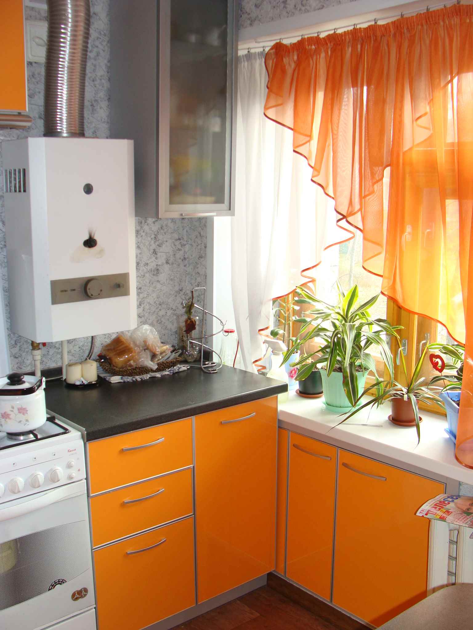 un esempio di un arredamento luminoso di una cucina con uno scaldabagno a gas