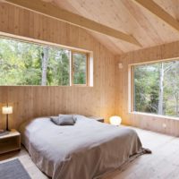bedroom in a wooden house with windows