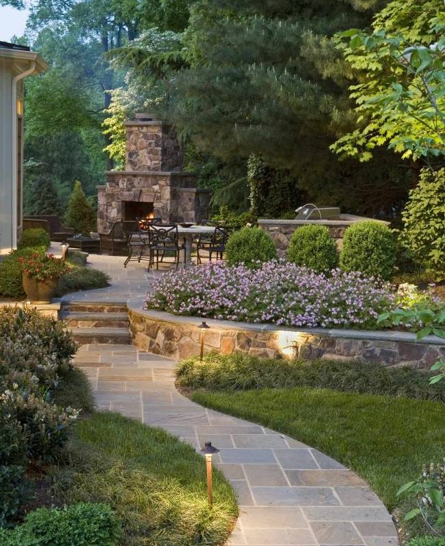 Stone retaining and outdoor fireplace in the background of the cottage
