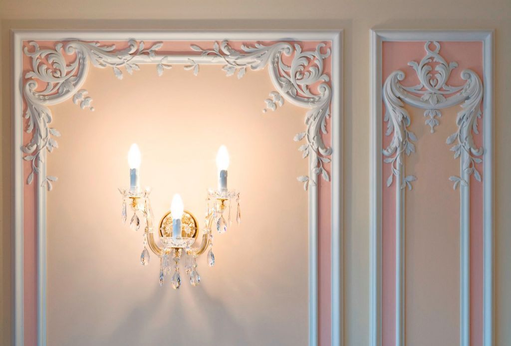 Wall decoration with stucco and sconces in the form of old candles