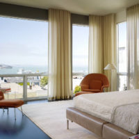 Finestre panoramiche del soggiorno con tende color crema