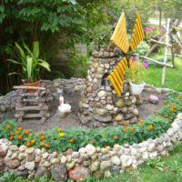 Homemade stone mill in a garden flower bed