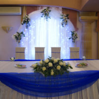 Mėlynas tiulis aplink vestuvių stalo kraštus