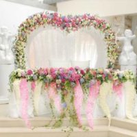 Floral arrangements in the design of the table of the bride and groom