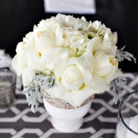 Šventinė baltų gėlių puokštė ant jaunavedžių stalo