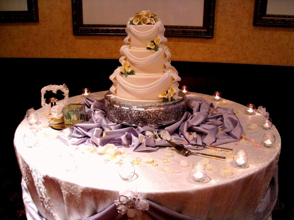 Wedding cake on a table surrounded by candles