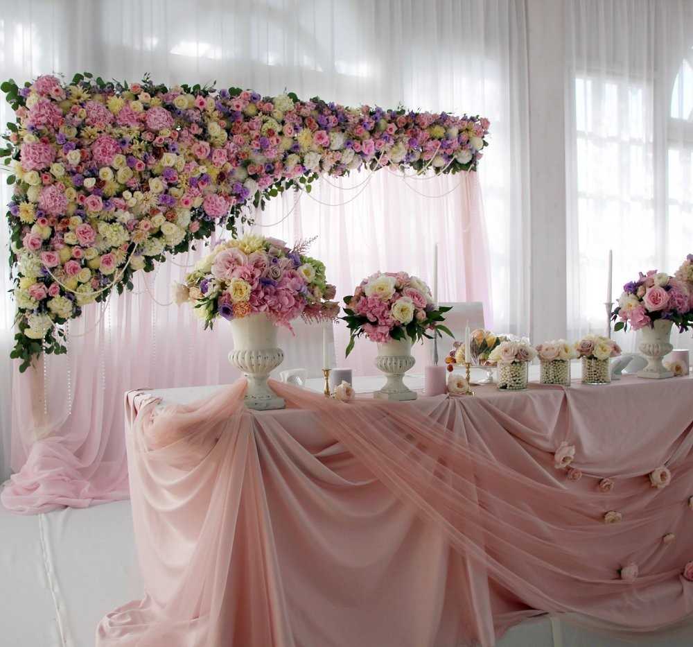 Décoration de table de mariage avec des couleurs claires et un tissu translucide.