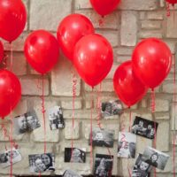 Helium balloons and photos in the design of a birthday room