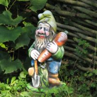 Homemade gnome with a carrot in the design of the garden