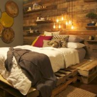 Bed on old pallets in a rustic bedroom