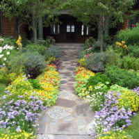 Jardin de fleurs variées devant la porte d'entrée