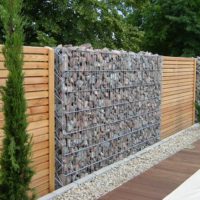 Combination of gabions with a wooden fence