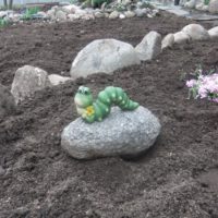 Decorative caterpillar on a stone as a decoration of a country garden