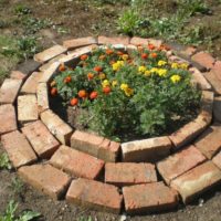Round flowerbed for marigolds made of old red brick