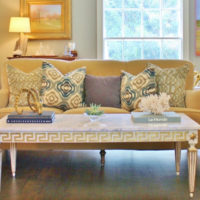 Un tavolo con gambe intagliate davanti a un divano nel soggiorno