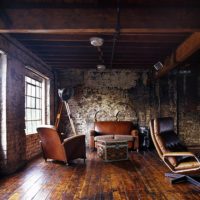 Leather chairs in the interior of the living room in the loft style