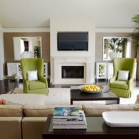 Two olive chairs in the living room with fireplace