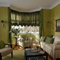 Olive shades in the ornament of wallpaper on the walls of the living room