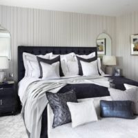 Striped wallpaper in the interior of a black and white bedroom