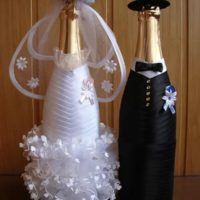 Bride dress and groom suit on champagne bottles