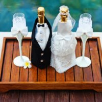 Bottiglie di champagne di nozze su un vassoio di legno