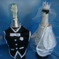 Groom's vest and bride's dress on wedding bottles
