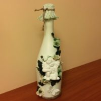 Figurina di angelo su una bottiglia di nozze champagne