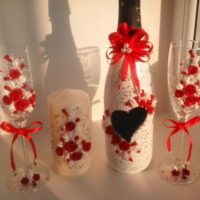 Fiori rossi e bianchi nella decorazione di bottiglie di champagne