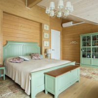 Mint color furniture in the bedroom of a wooden house