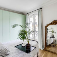 Mint-colored wardrobes and mirror in the bedroom