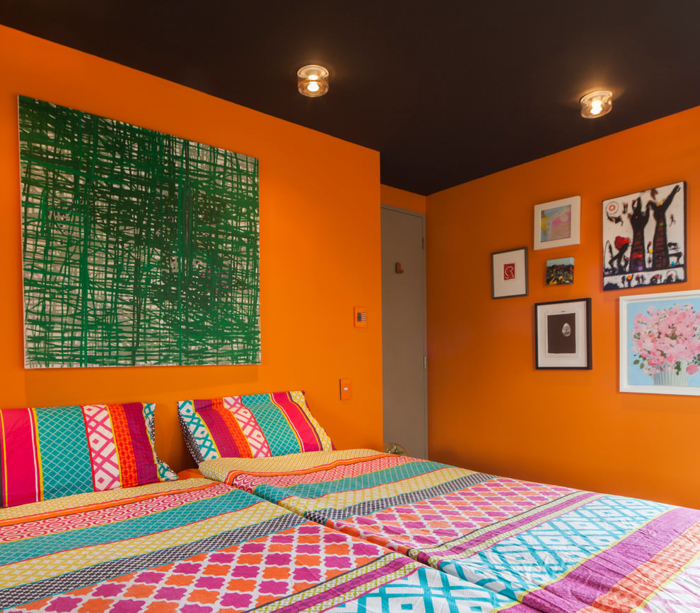 Colori arancione e marrone scuro all'interno della camera da letto per giovani