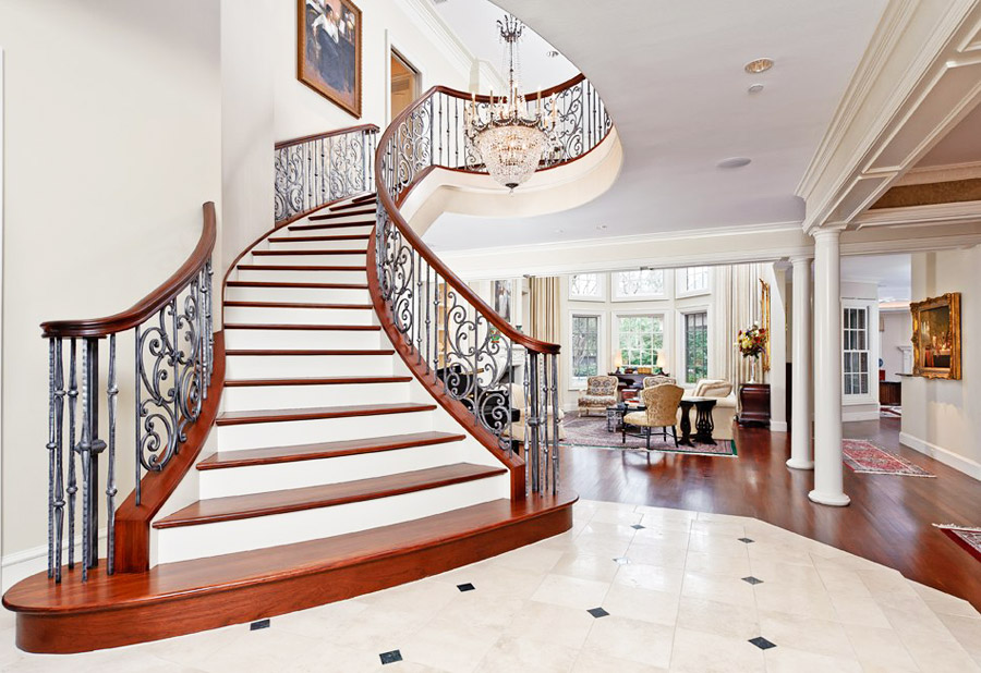 The interior of the hall of a country house with a staircase in a classic style