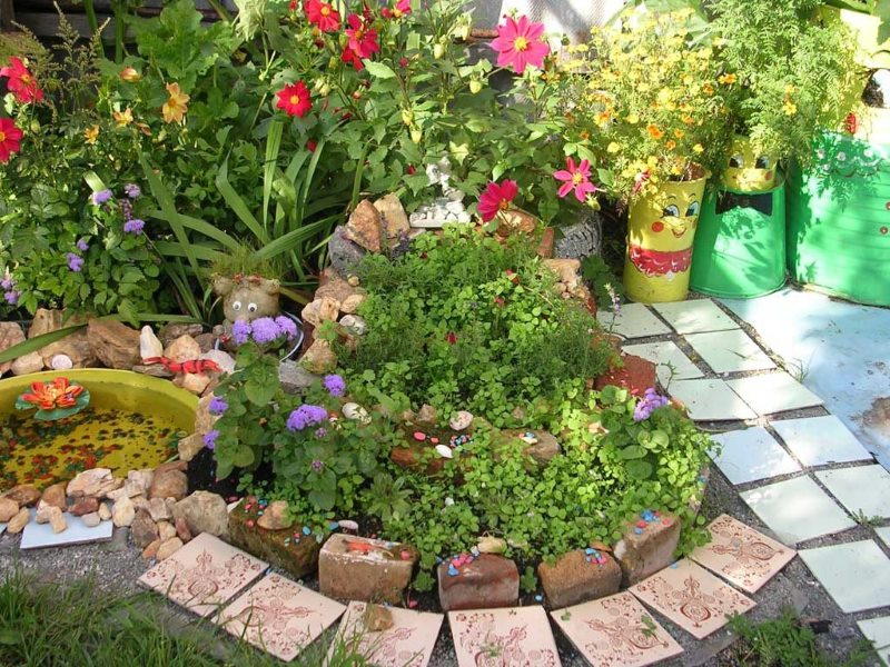 Flowerbed with flowers from old brick and other construction waste.