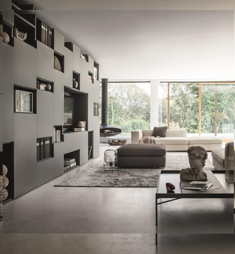 Gray bookcase with combined shelves in the interior of a fashionable living room