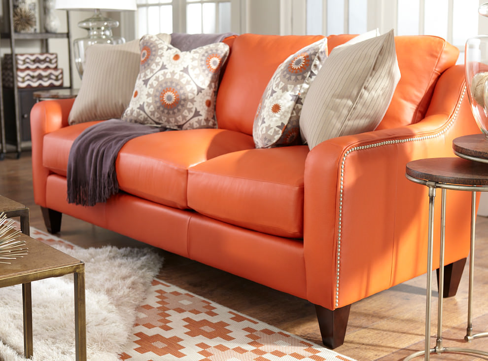 Orange leather sofa in the interior of the guest room