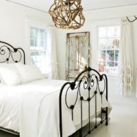 Black wrought iron bed in a white bedroom