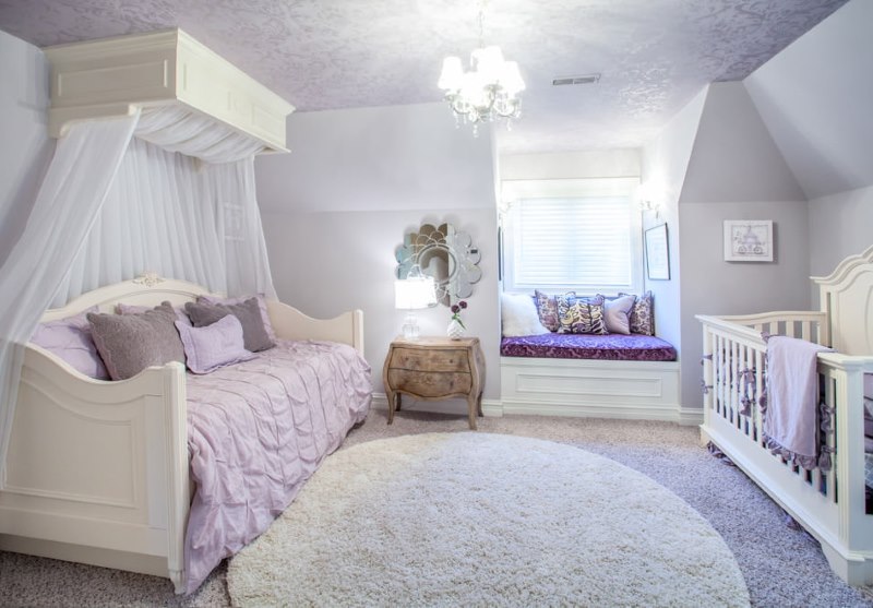 Interior of a room with a crib in lavender color