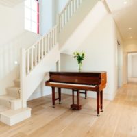 White hall with a piano in a country house
