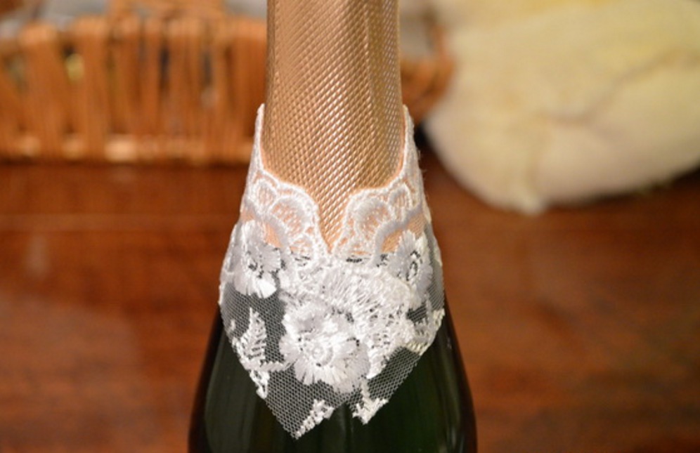 Adesivo in pizzo sul collo di una bottiglia di champagne per la decorazione sotto la sposa