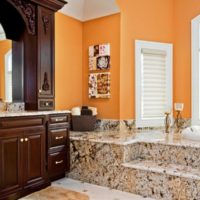 Orange walls and marble floor in the design of the bathroom