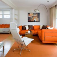 Interiore del salone con divano arancione vicino alla finestra