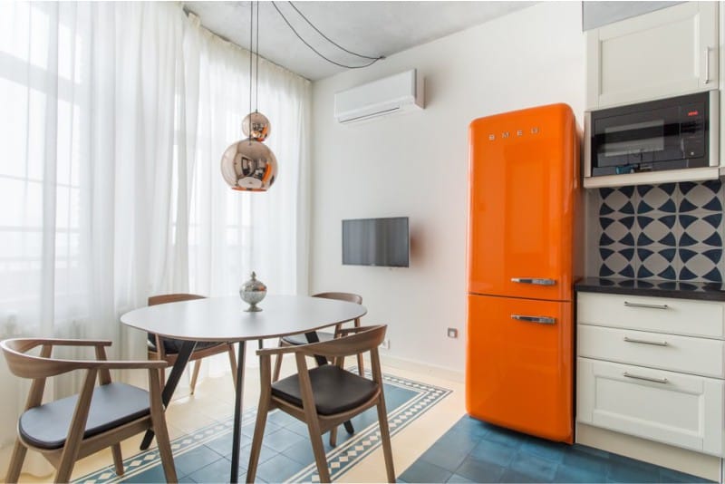 White kitchen design with orange fridge