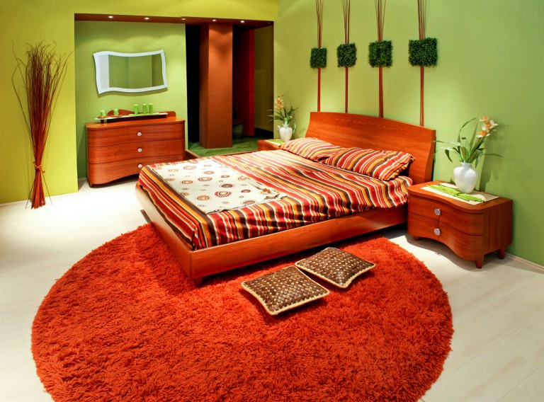 Orange bed and carpet in the bedroom interior