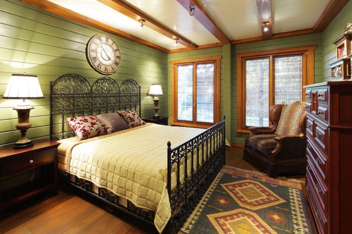 L'interno della camera da letto in colori verde oliva combinato con il colore naturale del legno