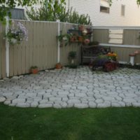 Parco giochi nell'angolo del giardino con piastrelle di cemento fatte in casa