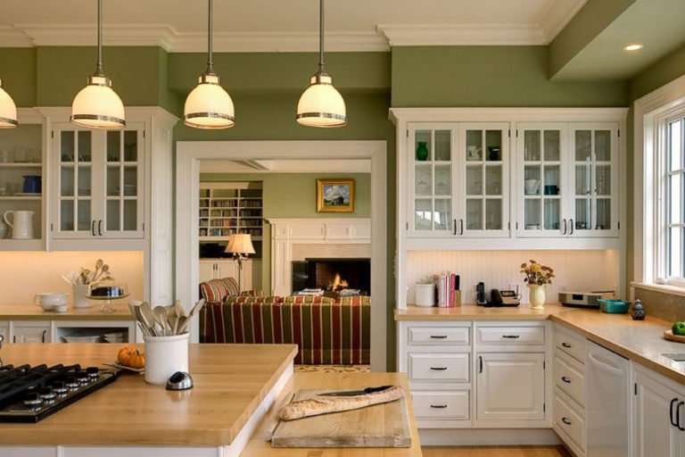 Interno cucina con set bianco e pareti verde oliva
